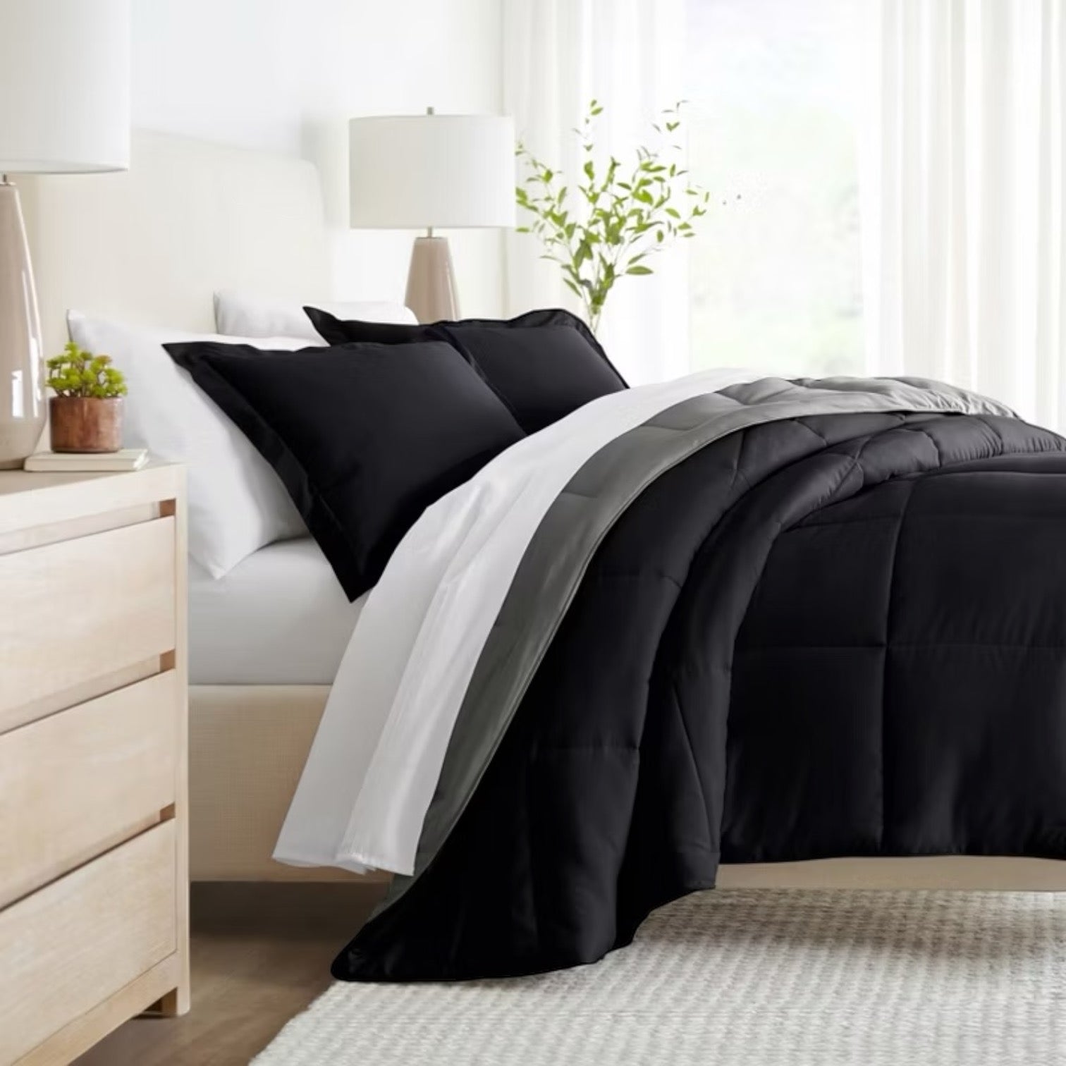 Cubrecama reversible negro y plomo de algodón pima en dormitorio iluminado