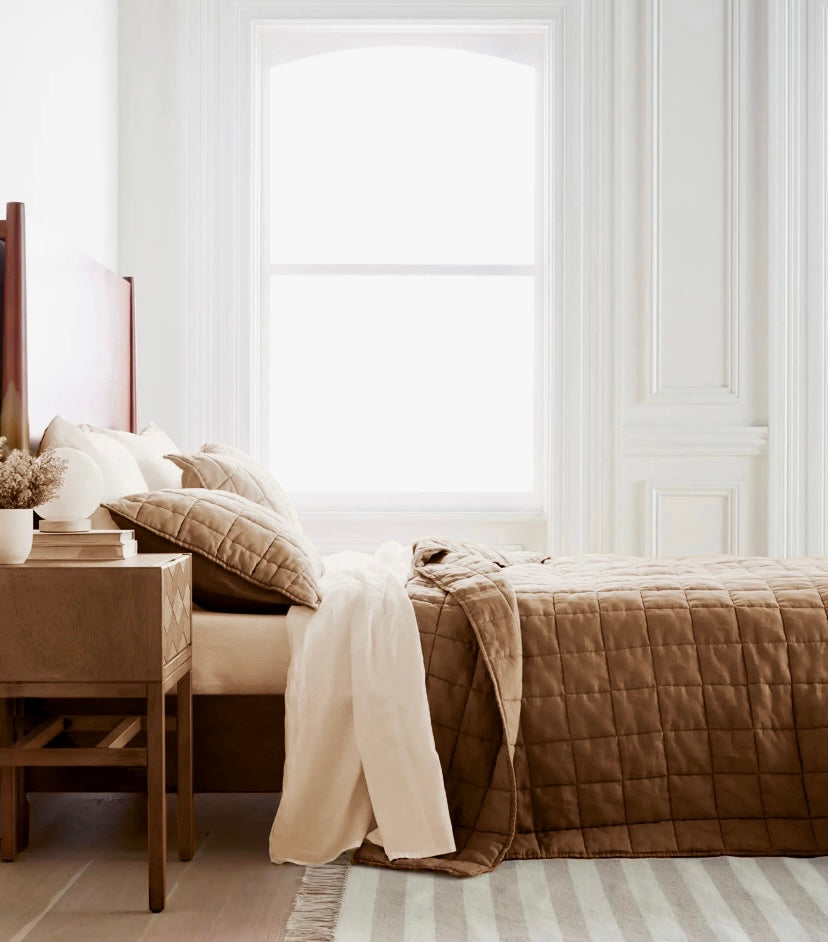 cuarto en una cama con su cubrecama en un día soleado